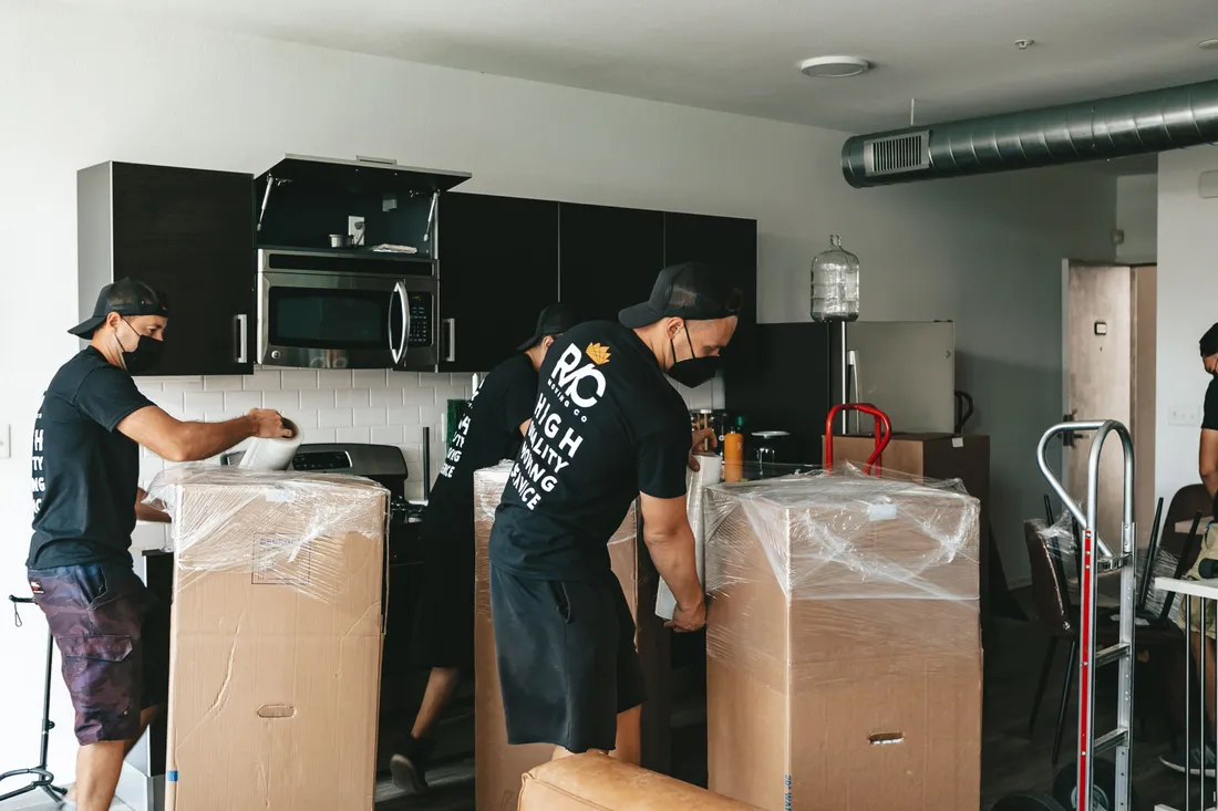 Team von BBE Umzüge & Transporte trägt Möbel zum Transporter in Berlin